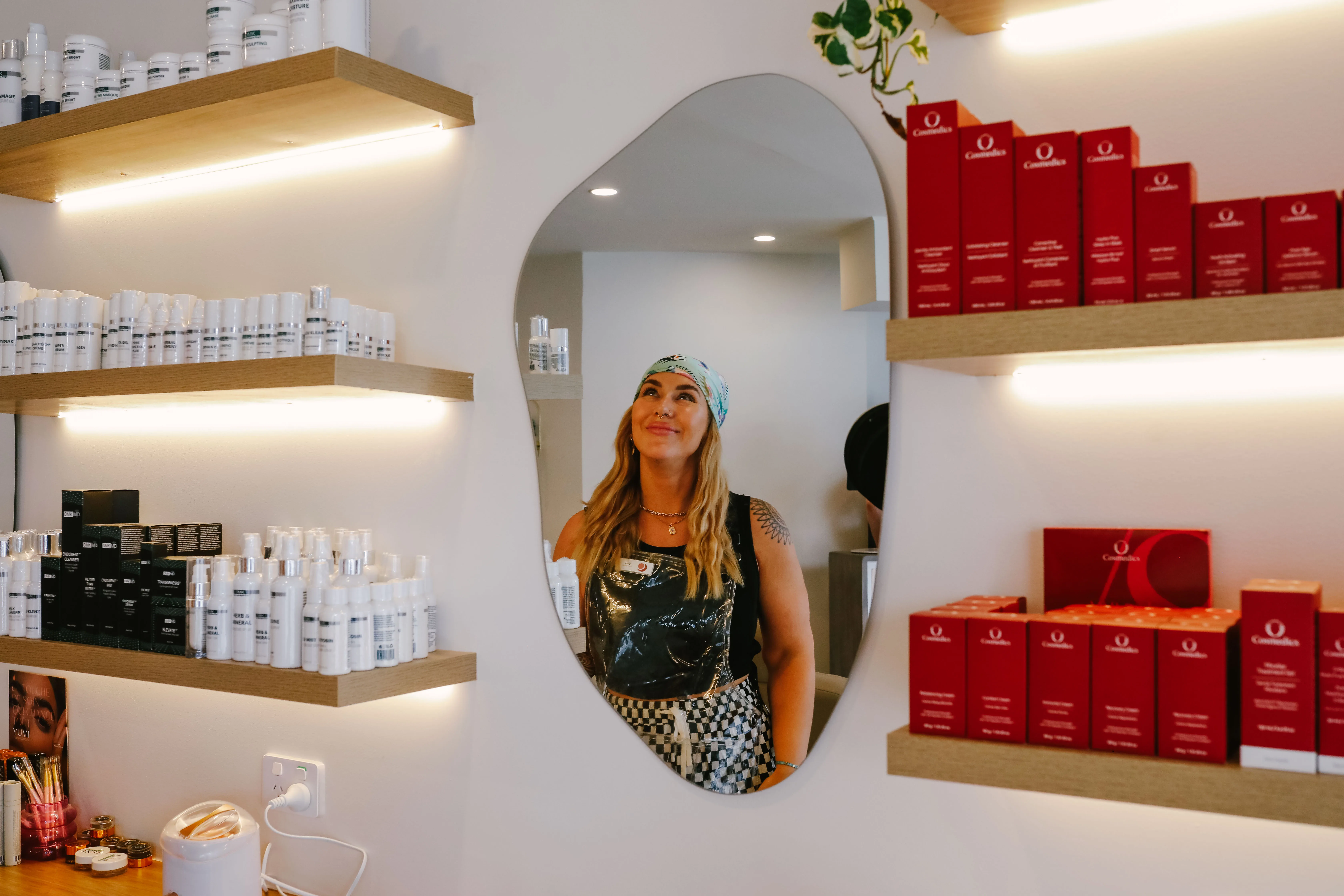 Retail wall with pebble-shaped mirror at LUNA Skin + Brow Brunswick East