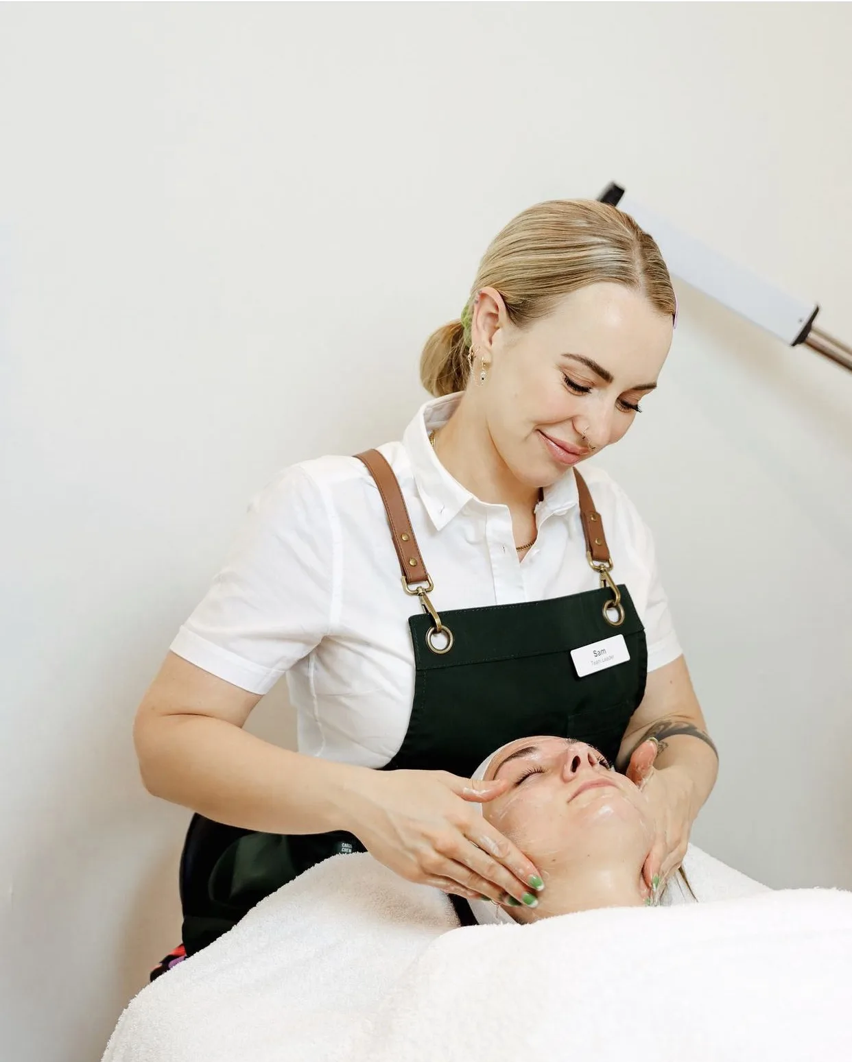 Therapist cradling a client's face during a facial treatment at LUNA