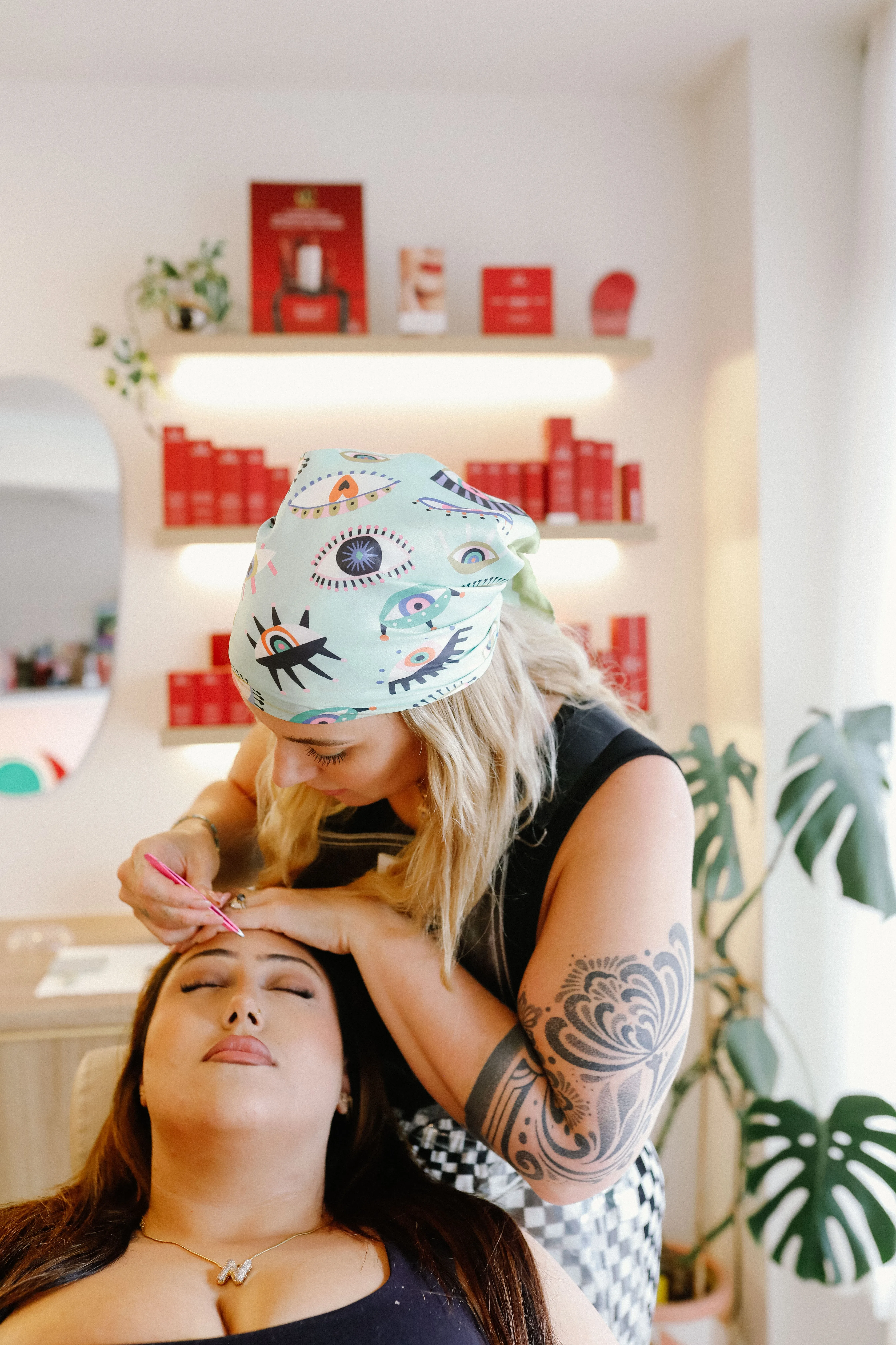 Therapist shaping a client's brow with precision tweezers at LUNA